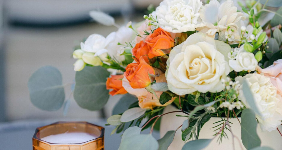 melrose flower lab vase with white and orange flowers on a table