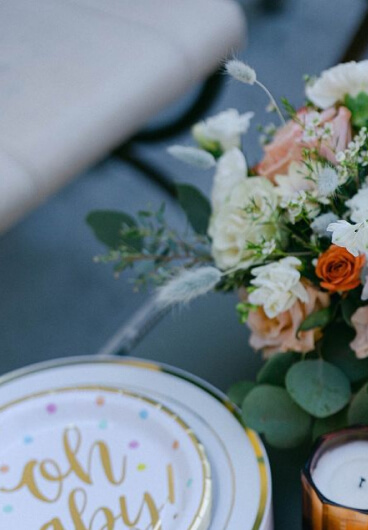 melrose flower lab white plate with the name of the baby written on it placed on a baby shower table